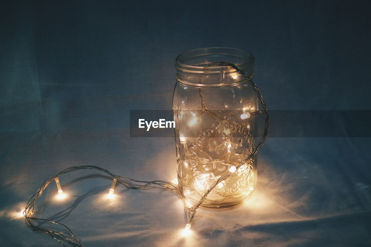 Close-up of illuminated lights in jar on table