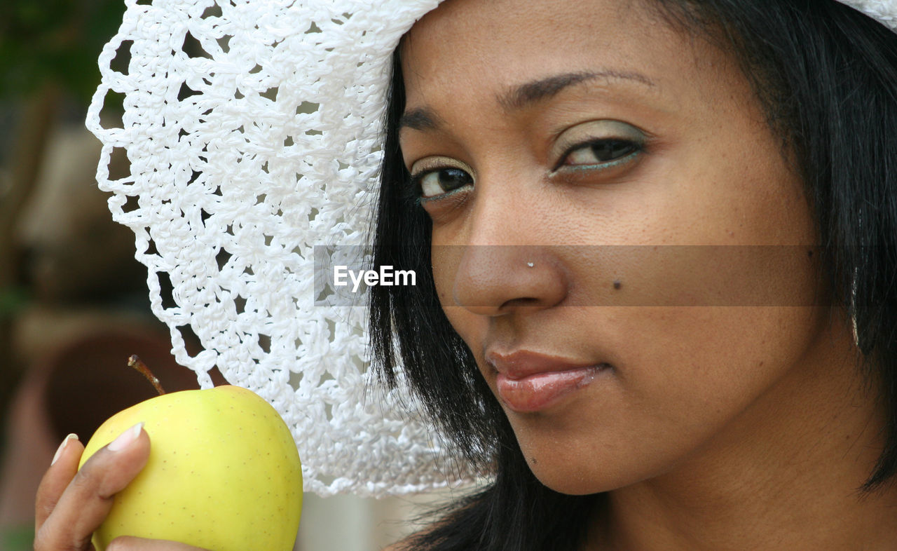 Portrait of beautiful woman holding apple