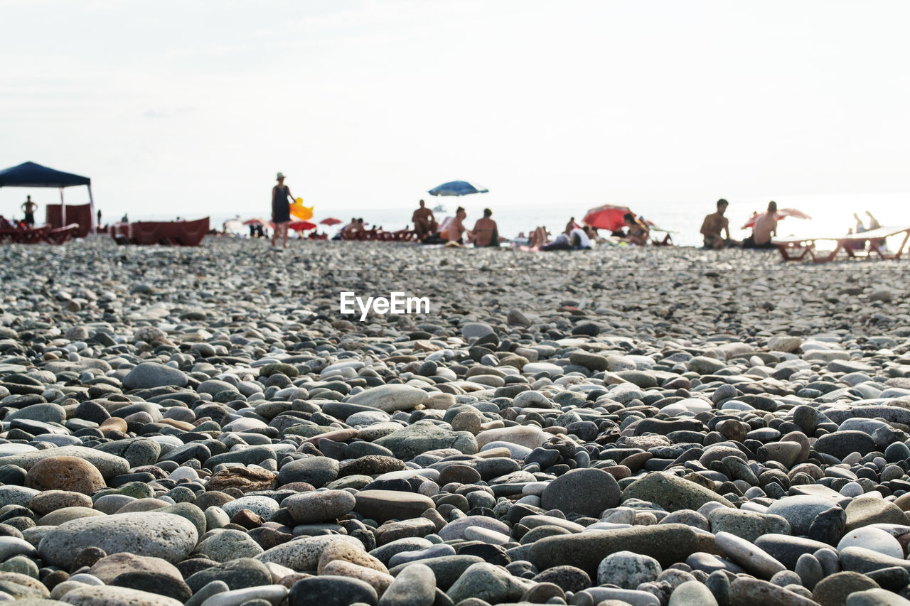 PEOPLE AT BEACH AGAINST SKY