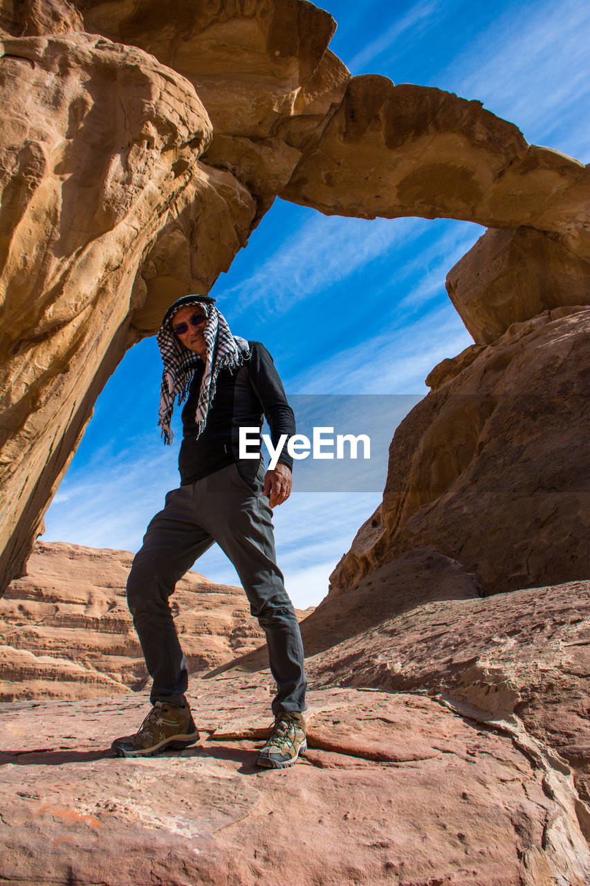 Portrait of man standing against rock formation