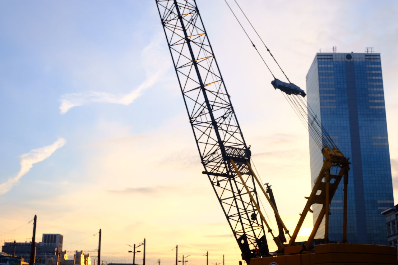 LOW ANGLE VIEW OF CRANES AT CONSTRUCTION SITE