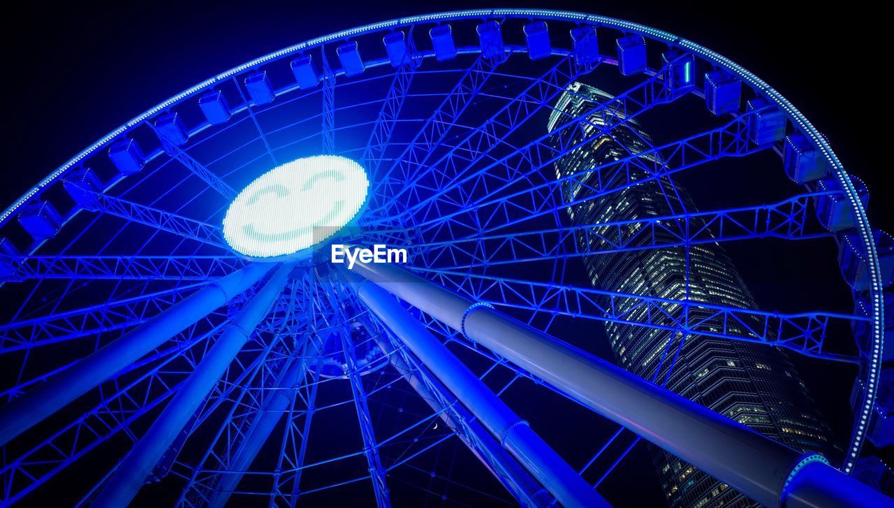 LOW ANGLE VIEW OF FERRIS WHEEL AT NIGHT
