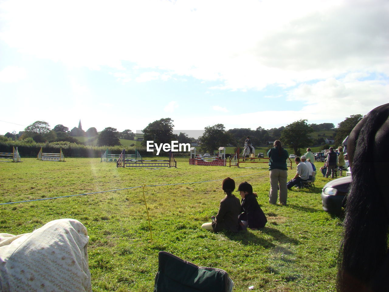 PEOPLE ON GRASSY FIELD AGAINST SKY