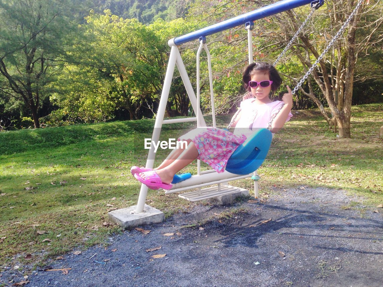Full length of girl sitting on swing at park