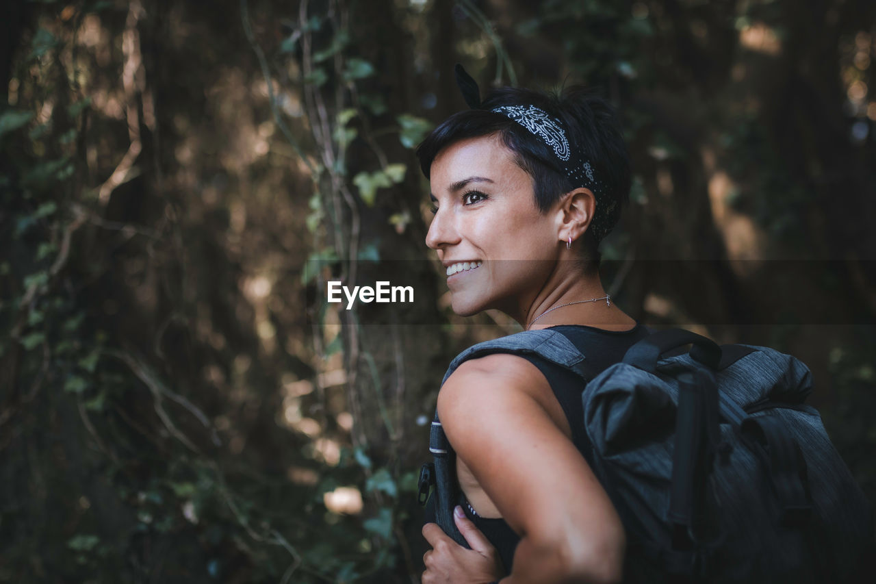 Smiling woman standing in forest