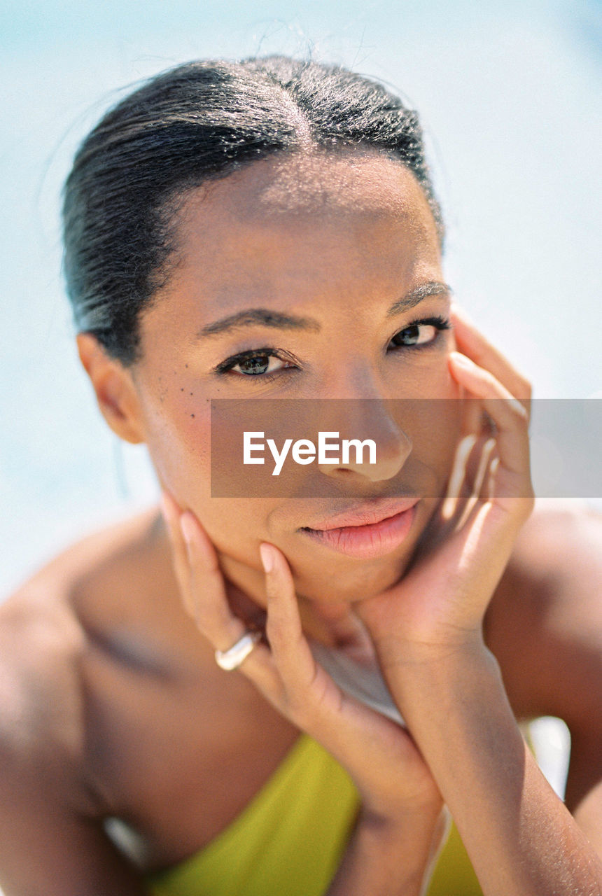 close-up portrait of shirtless young woman against sky