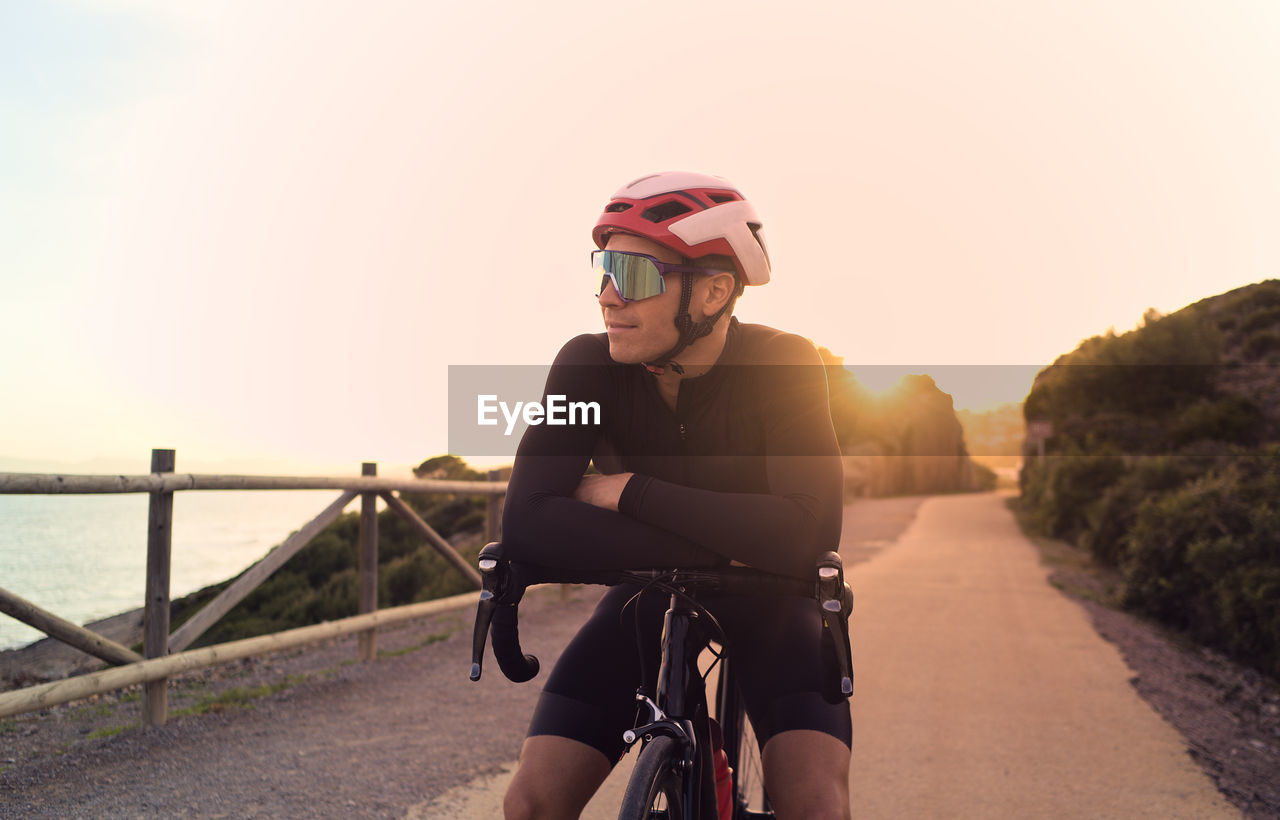 Cyclist resting at sunset during a training session.