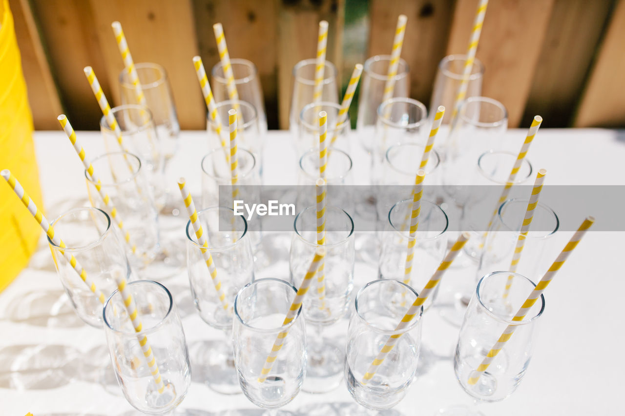 High angle view of straws in empty glasses on table