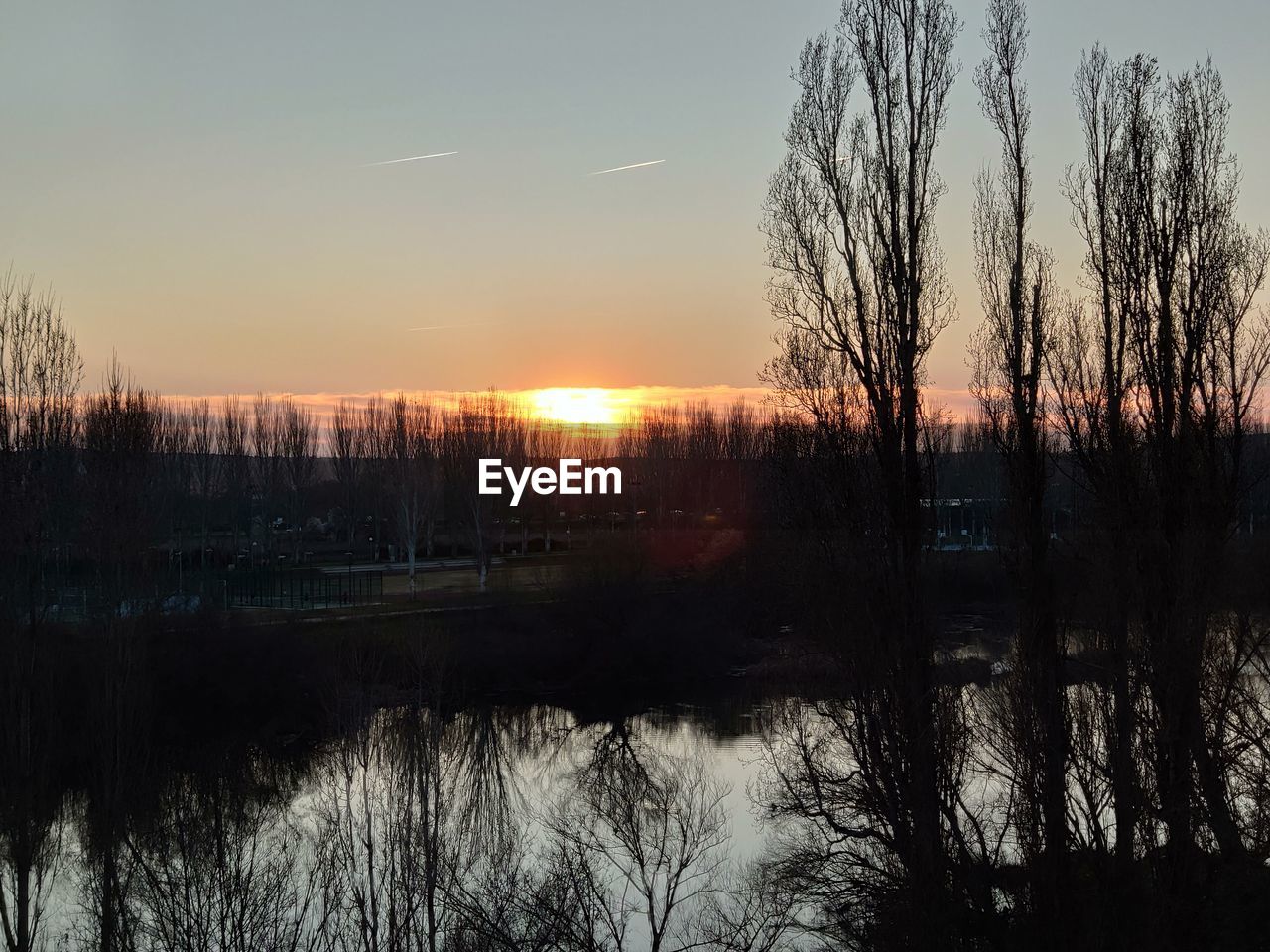 SCENIC VIEW OF LAKE AGAINST SKY AT SUNSET