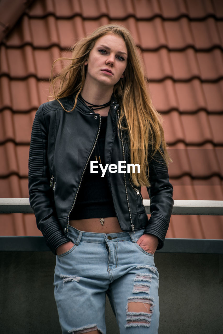 Beautiful young woman against roof