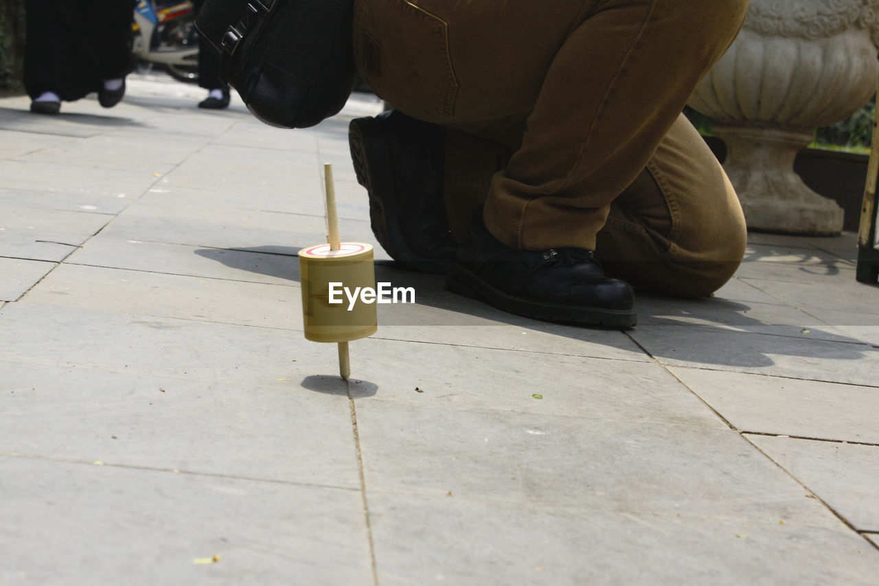LOW SECTION OF MEN ON STREET BY COBBLESTONE