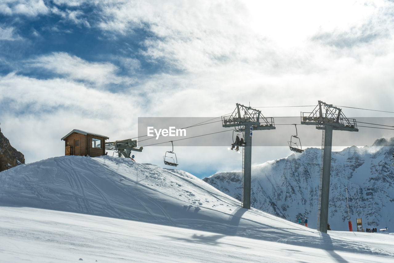 Chairlifts rising into the station at the top of the mountain on a sunny day in les arcs