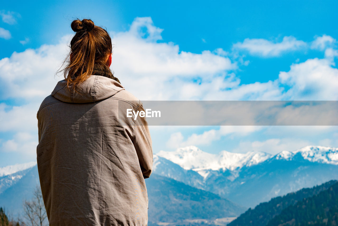 Rear view of woman looking at snowcapped mountains