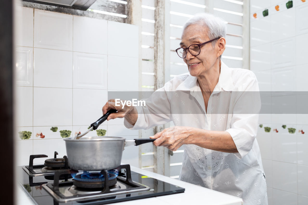 MAN PREPARING FOOD IN KITCHEN AT HOME