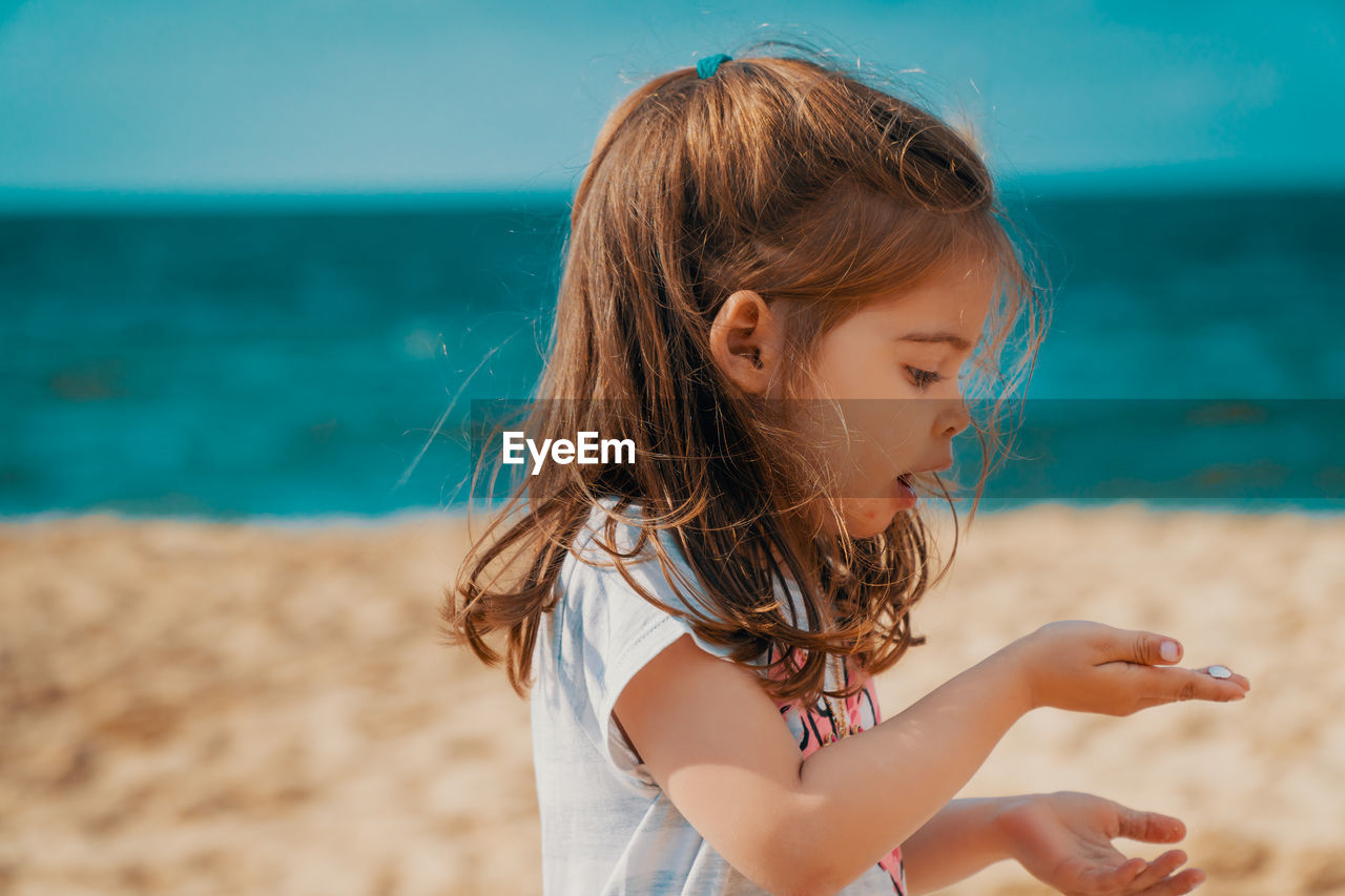 Girl holding seashell at beach