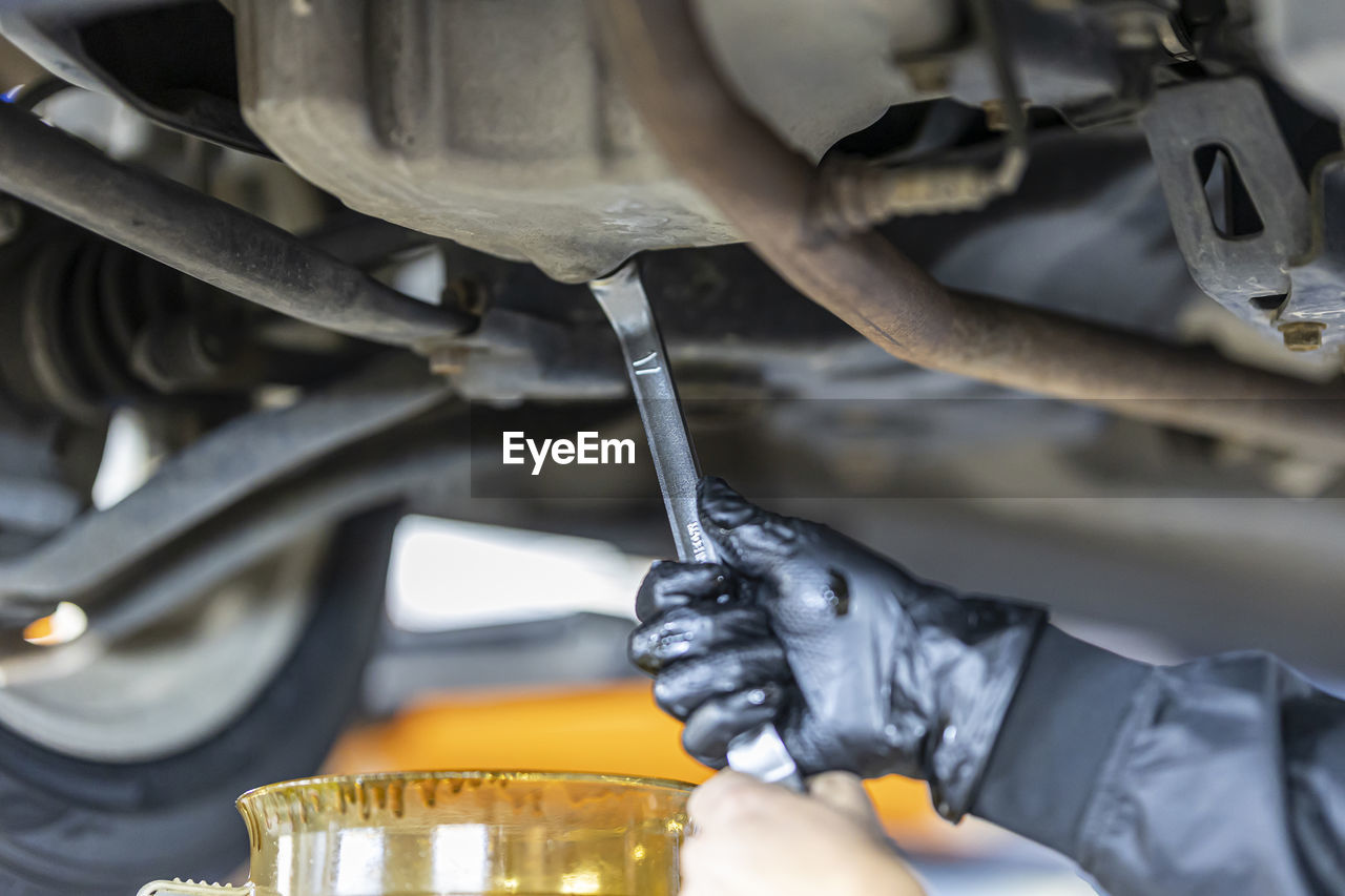 close-up of man repairing car engine