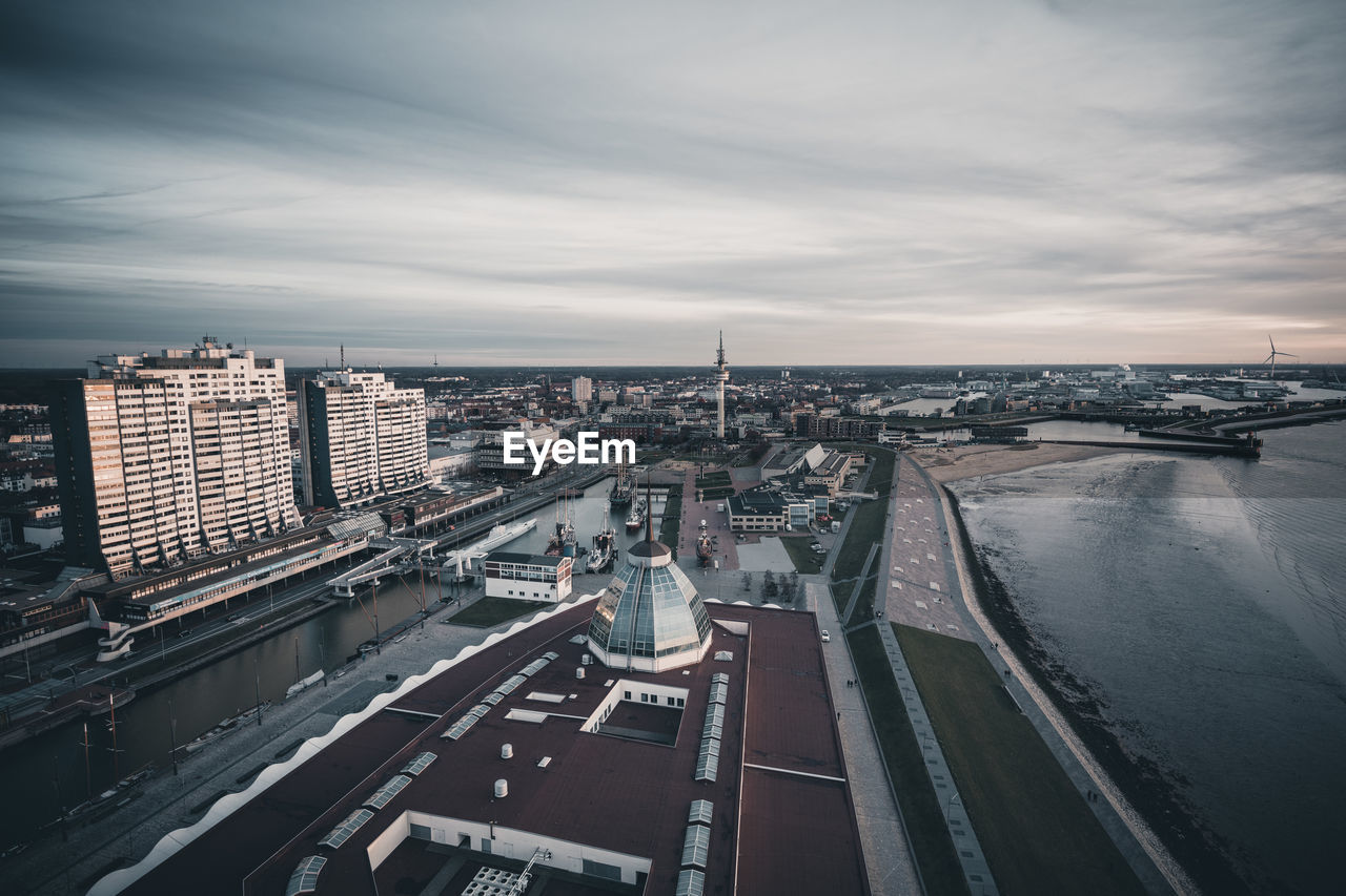 HIGH ANGLE VIEW OF CITYSCAPE AND RIVER AGAINST SKY