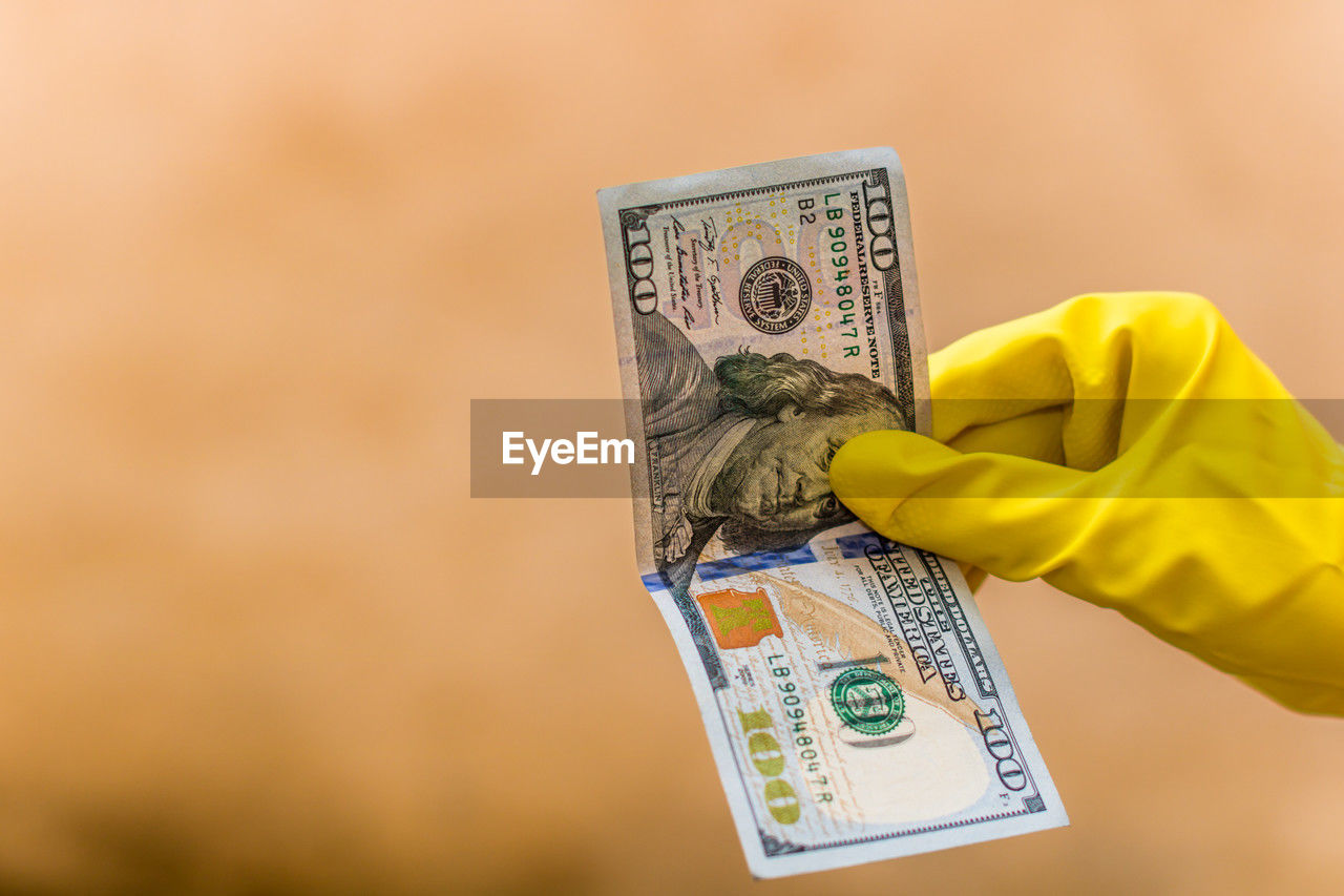 paper currency, currency, finance, wealth, business, cash, money, business finance and industry, hand, finance and economy, savings, yellow, holding, one person, paying, buying, protection, security, adult, close-up, economy, banking, dollar, consumerism, retail, copy space, home finances, occupation