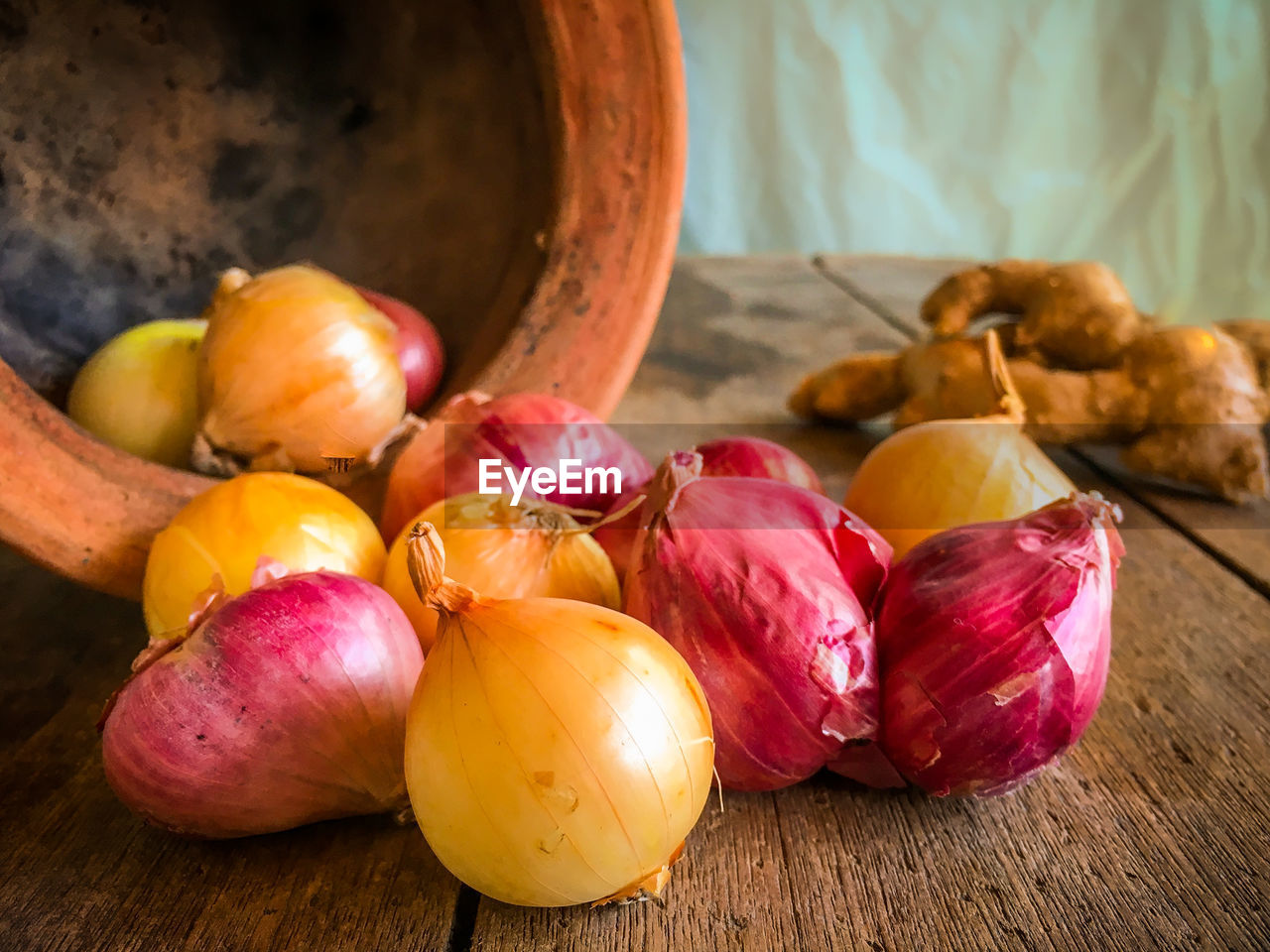 Onions spilling from pottery on table