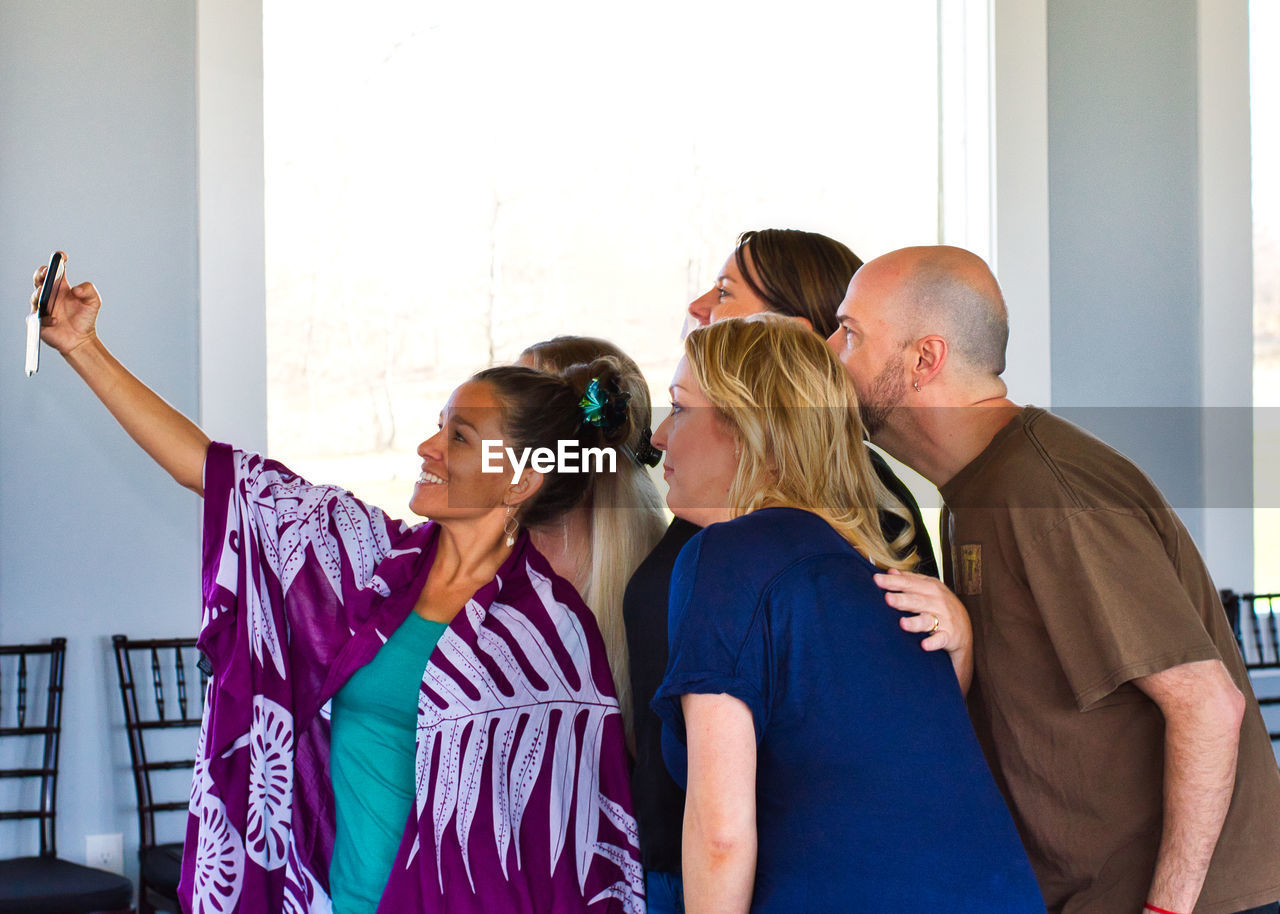 REAR VIEW OF COUPLE STANDING AGAINST WALL