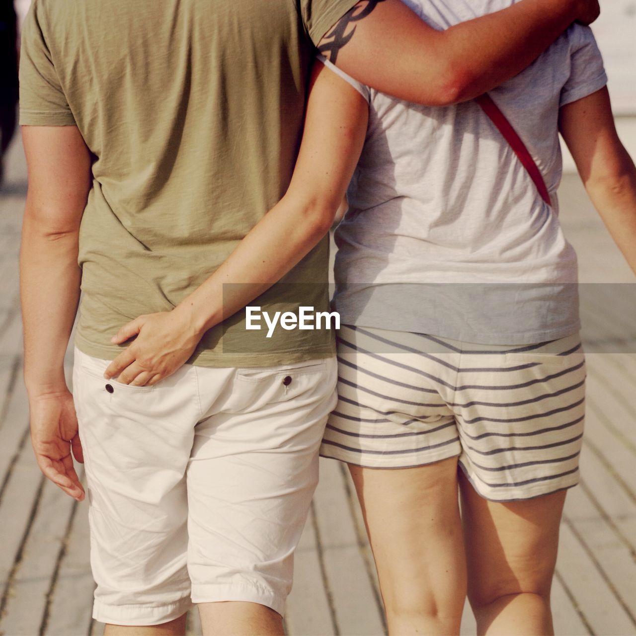 Midsection of man and woman walking on street