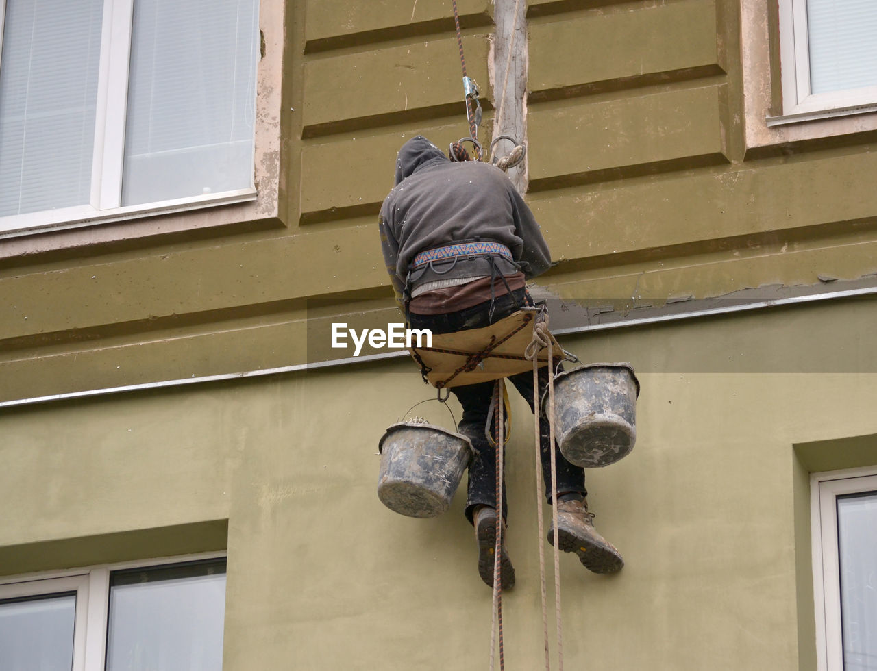LOW ANGLE VIEW OF MAN WORKING OUTSIDE HOUSE