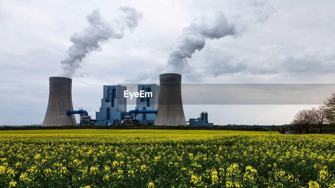 Scenic view of smoke emitting from factory against sky