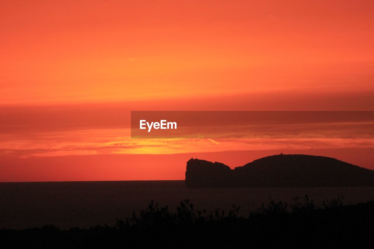 SCENIC VIEW OF SILHOUETTE MOUNTAIN AGAINST ORANGE SKY