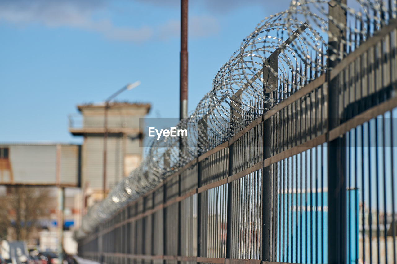 Barbed wire on fence, steel grating fence, metal fence wire. private area, protection, safety