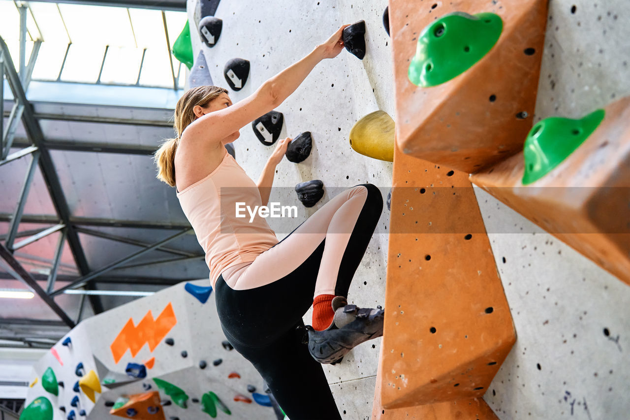 Woman training at bouldering gym. active recreation, sports exercises