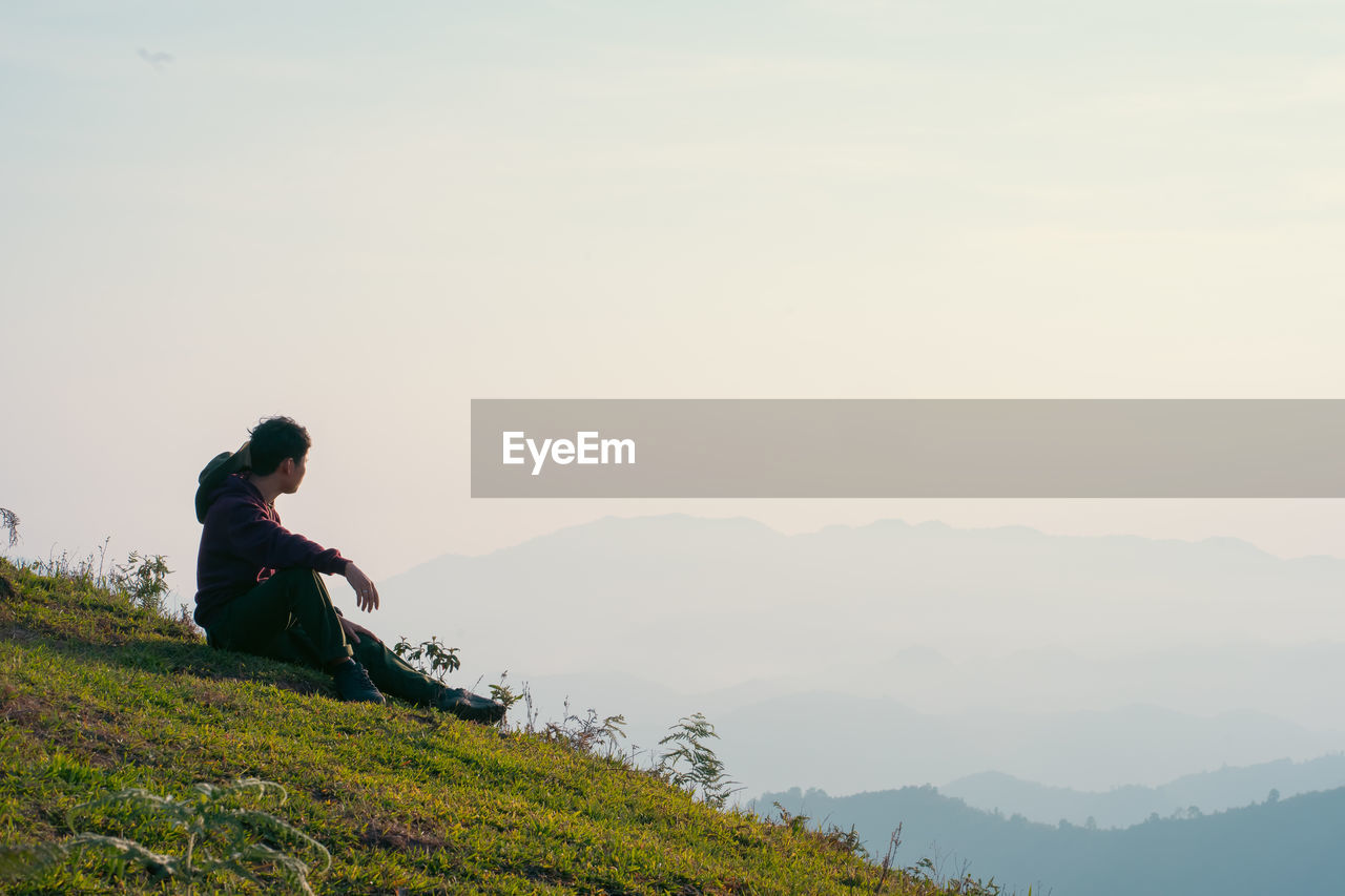 low angle view of man standing on mountain against sky