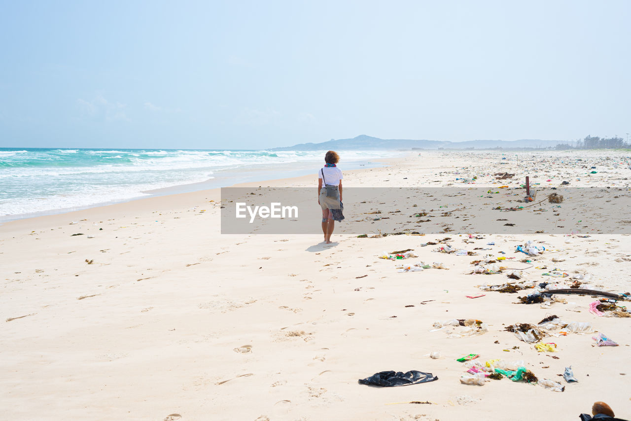 FULL LENGTH REAR VIEW OF MAN ON BEACH