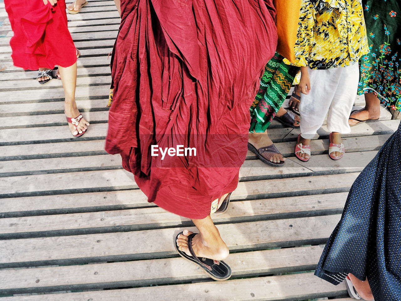 Low section of women walking on wooden footbridge