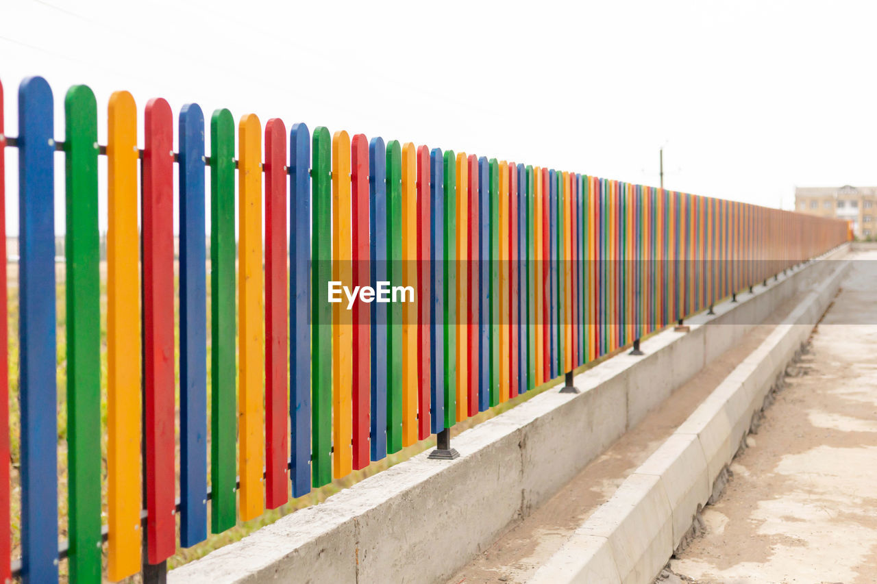 CLOSE-UP OF MULTI COLORED FENCE