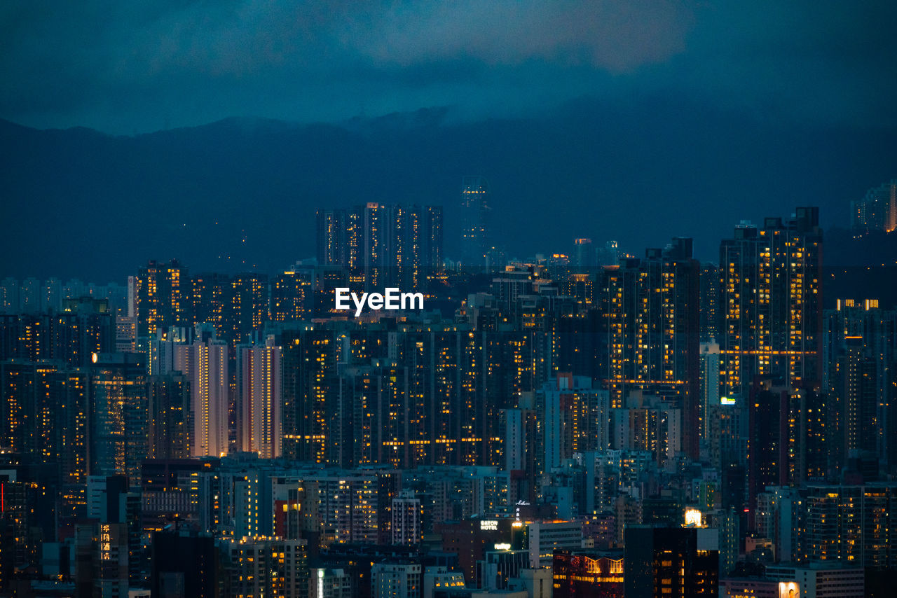 AERIAL VIEW OF ILLUMINATED BUILDINGS IN CITY AT NIGHT