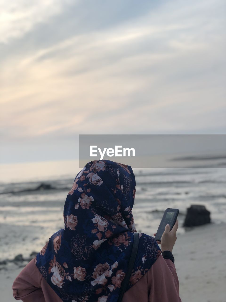 Portrait of woman on beach against sky during sunset