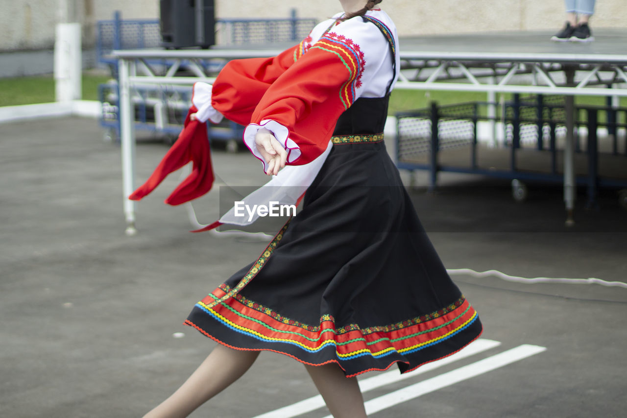 A girl dances russian folk dance. performance of a girl with a folk dance on the street. person