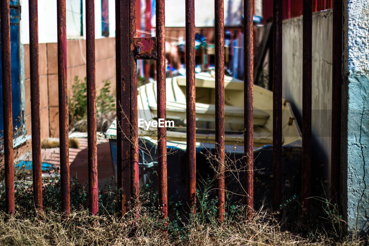 Rusty metal gate by abandoned boat