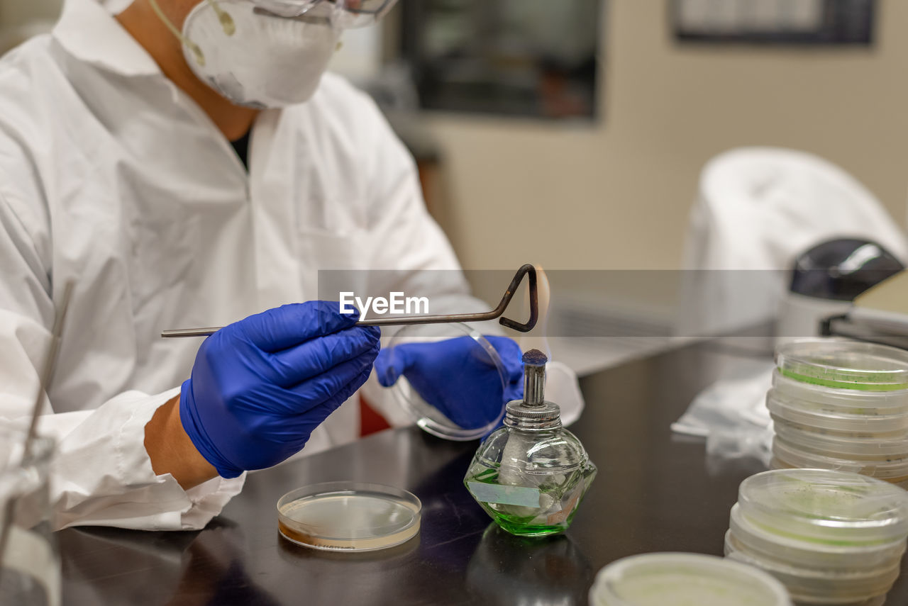 Midsection of male scientist experimenting in laboratory