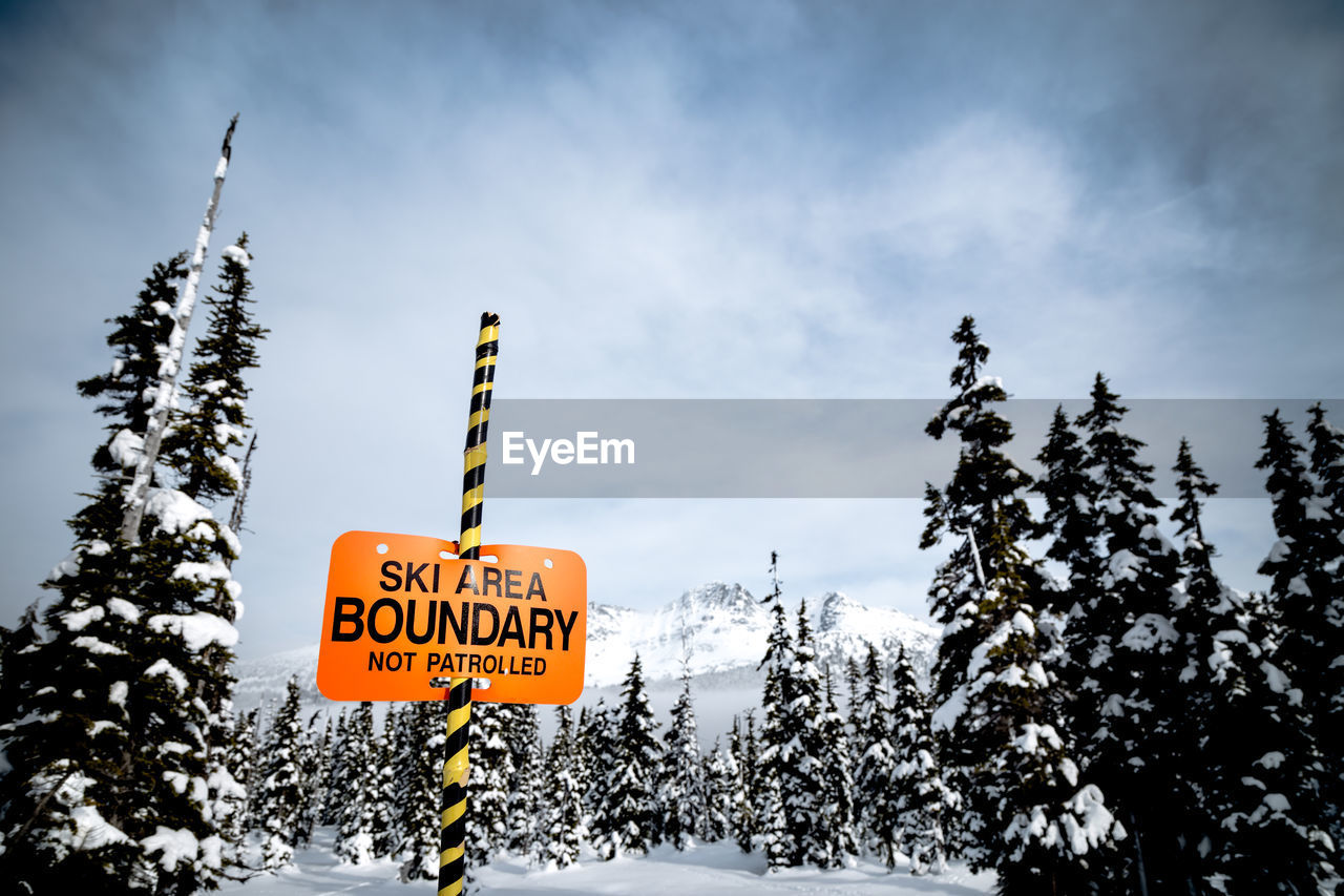 LOW ANGLE VIEW OF INFORMATION SIGN AGAINST SKY