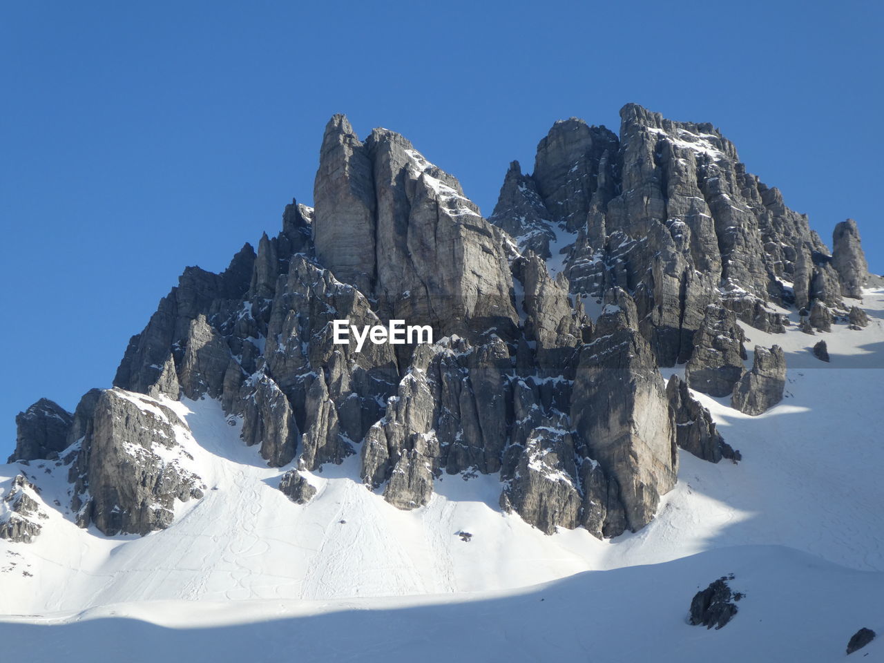 snow, cold temperature, winter, mountain, scenics - nature, sky, mountain range, beauty in nature, nature, environment, landscape, snowcapped mountain, blue, ski mountaineering, clear sky, sports, mountaineering, ridge, ski touring, mountain peak, travel destinations, summit, sunny, winter sports, massif, travel, rock, no people, day, outdoors, arête, leisure activity, sunlight, piste, tranquil scene, tranquility, ice, frozen, mountain climbing, white, land