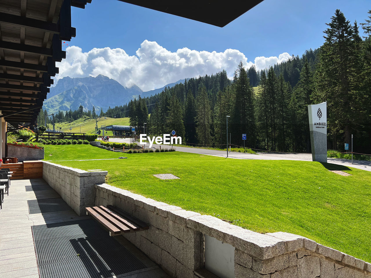 plant, grass, mountain, sky, architecture, tree, nature, beauty in nature, scenics - nature, built structure, green, travel destinations, landscape, estate, environment, mountain range, no people, tranquility, land, building exterior, travel, tranquil scene, day, sports, building, house, leisure activity, outdoors, coniferous tree, tourism, sport venue, cloud, summer, lawn, sunlight