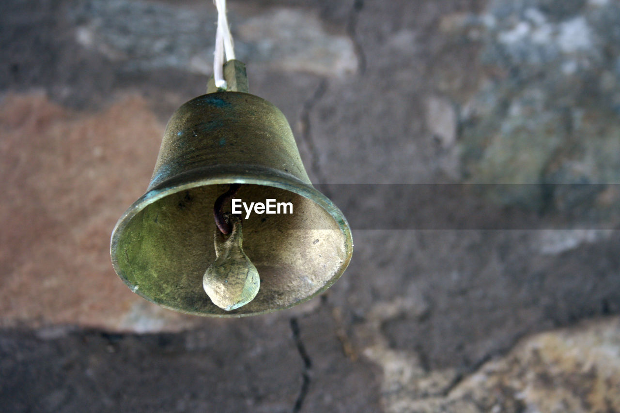 CLOSE-UP OF BELL HANGING ON WALL