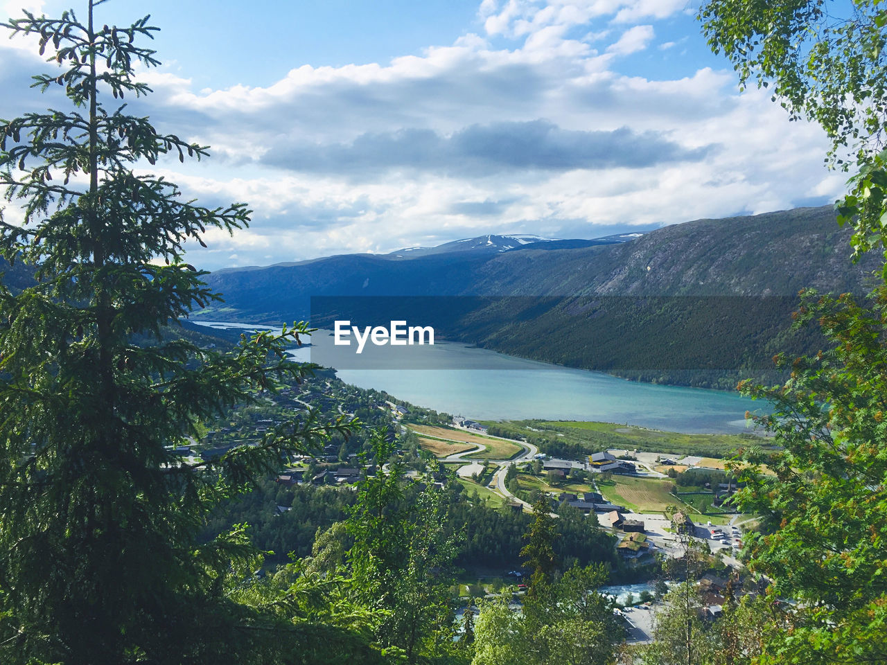 Scenic view of river by mountains against sky