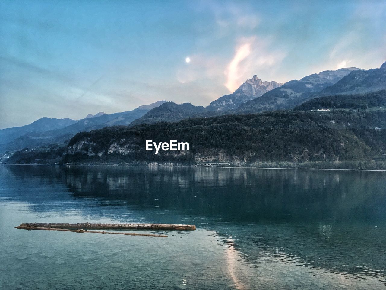 Scenic view of lake by mountains against sky