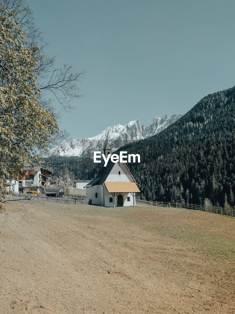 Houses on field by mountains against sky