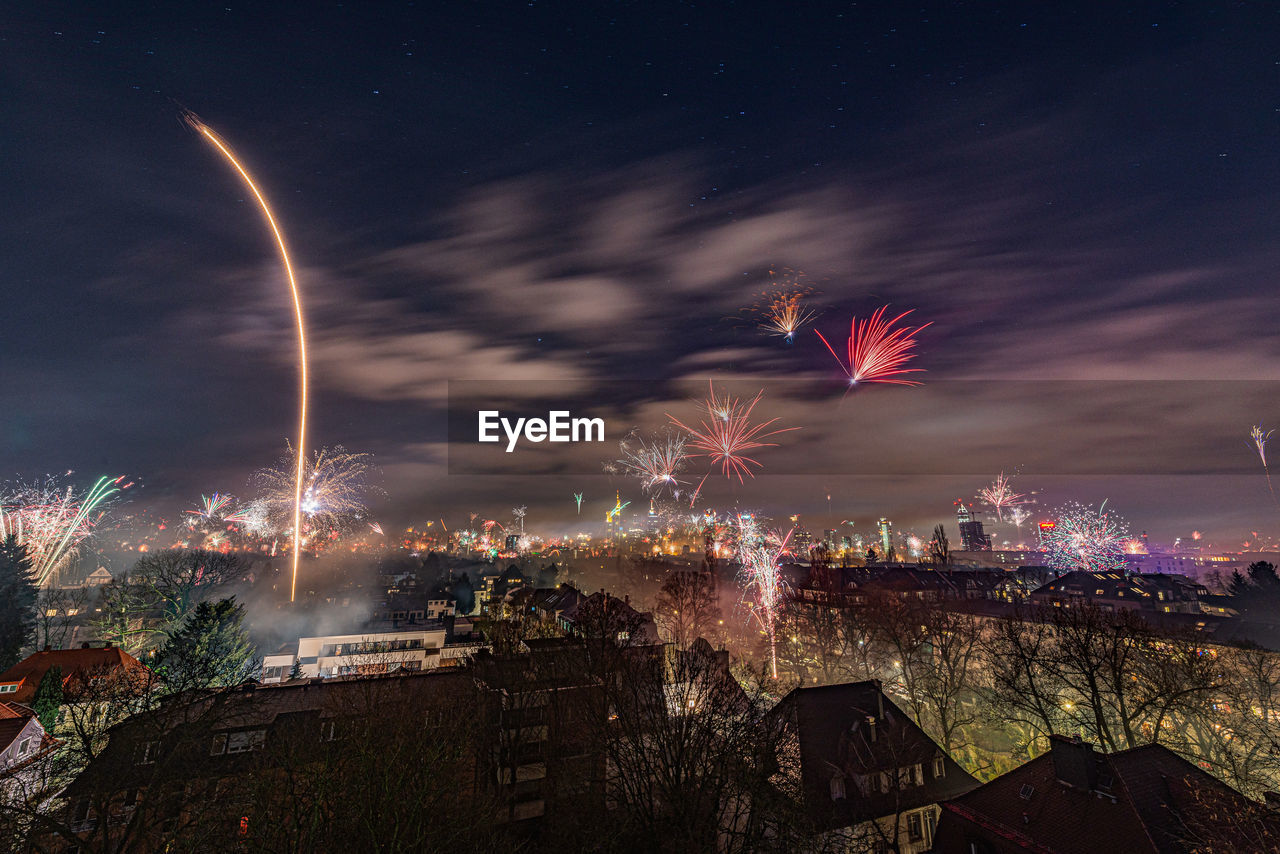 FIREWORK DISPLAY OVER ILLUMINATED BUILDINGS IN CITY