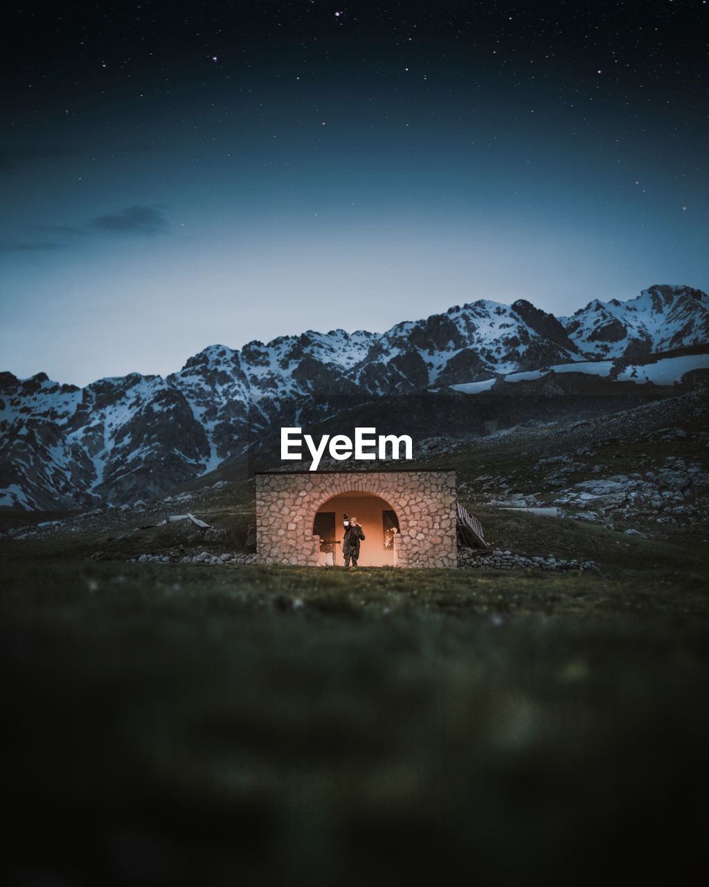 MAN ON MOUNTAIN AGAINST SKY AT NIGHT DURING WINTER