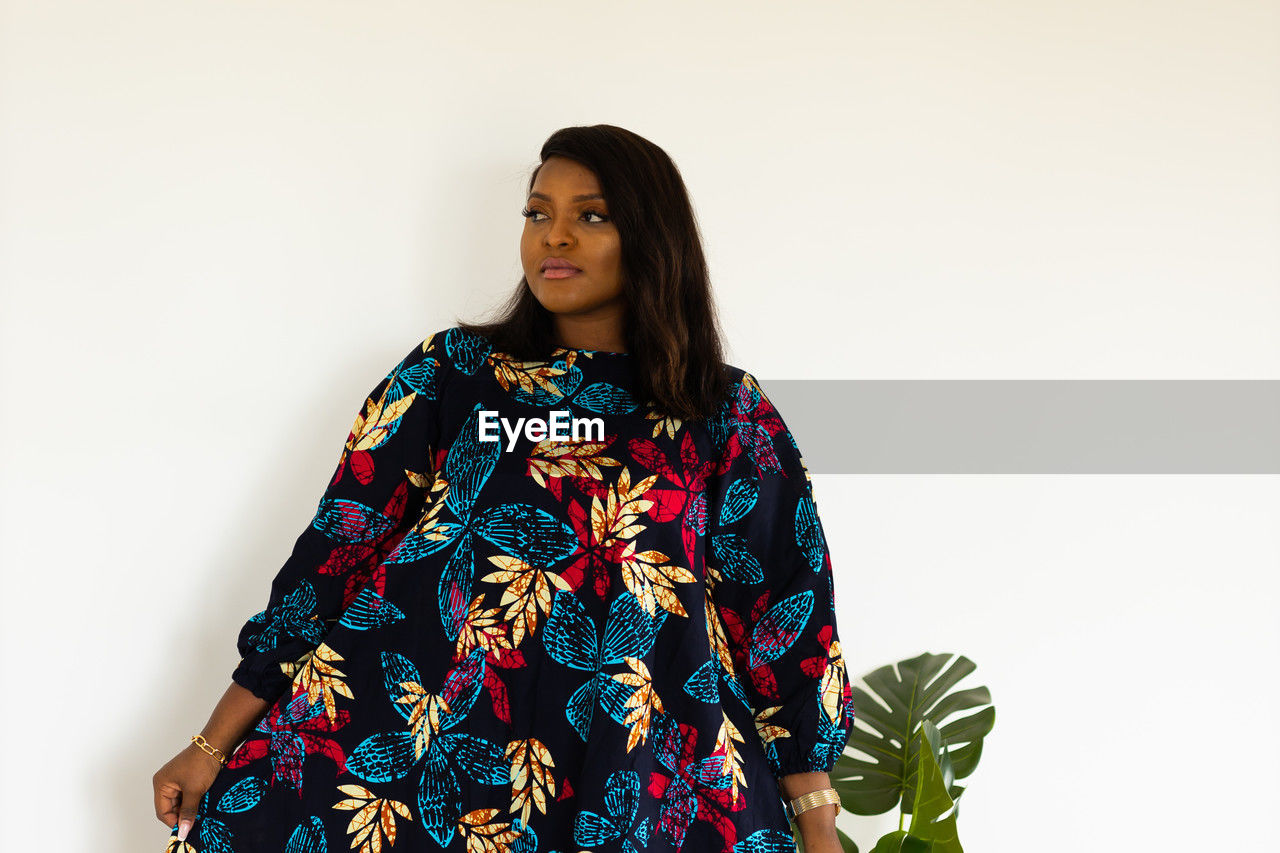 one person, women, adult, portrait, young adult, clothing, studio shot, indoors, white background, photo shoot, sleeve, copy space, fashion, pattern, dress, hairstyle, outerwear, flower, waist up, standing, front view, floral pattern, spring, female, three quarter length, looking, long hair, smiling, traditional clothing, lifestyles, multi colored, looking at camera, black hair