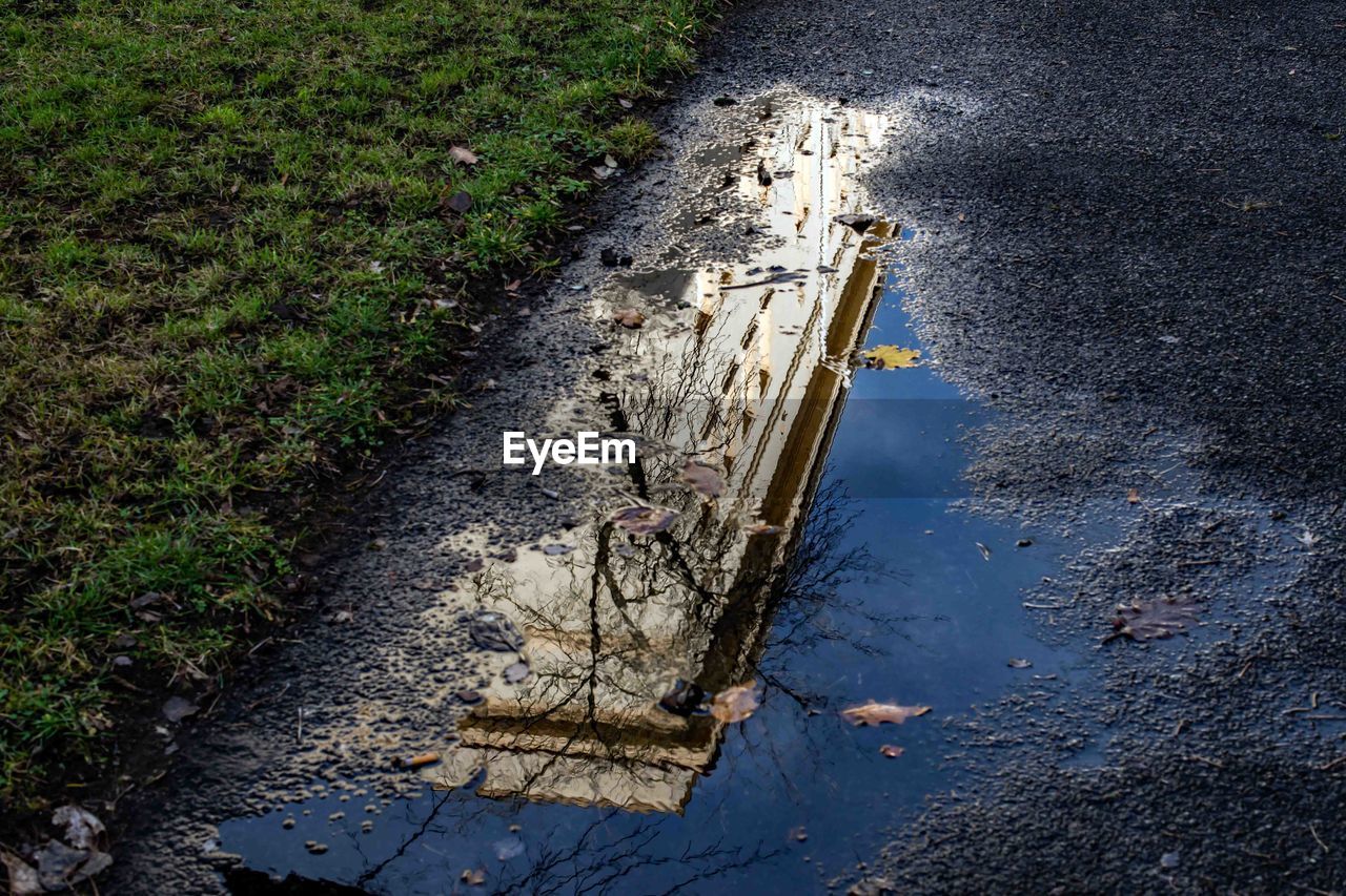 HIGH ANGLE VIEW OF PUDDLE ON ROAD BY STREET